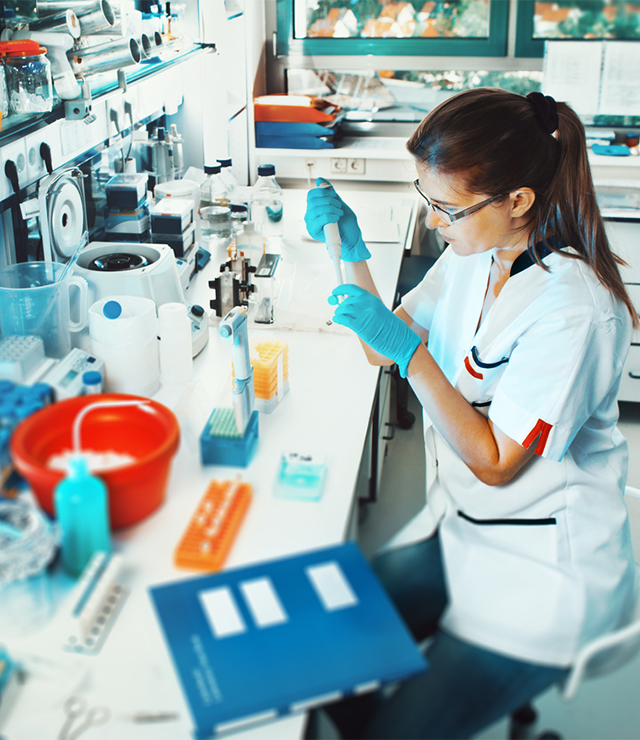 A woman conducts research in a science lab.
